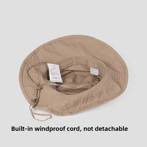 Détail de l'intérieur d'un chapeau kaki avec étiquette 100% polyester et cordon réglable