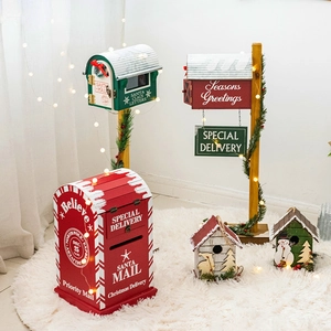Christmas mailboxes and miniature wooden cottages on a cozy white rug with warm lights