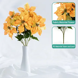 Artificial golden poinsettia flowers in a white ceramic vase for Christmas home decor