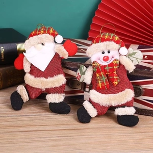 Detail of Christmas Santa and Snowman hanging plush dolls on a vintage suitcase