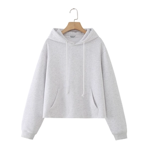 Detail of light gray hoodie with raw hem, large front pocket, and white drawstring cords