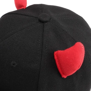 Close-up of black cotton twill baseball cap with red devil horns and top button detail
