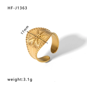 Detail view of gold stainless steel wide band ring with vintage texture and star motif
