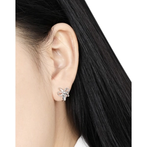Minimalist S925 sterling silver bow earrings worn by a model in a close-up fashion view