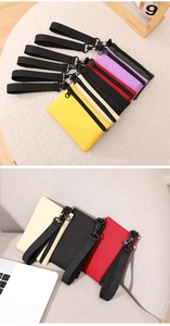 Gros plan de porte-monnaie en nylon coloré avec dragonnes et anneaux en D sur fond doux