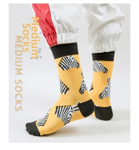 Detailed view of yellow crew socks featuring artistic zebra patterns and black cuffs