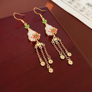 Detailed close-up of gold-plated Chinese style earrings with lotus and tassel pendants
