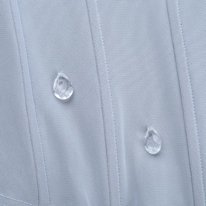 Macro d'un tissu bleu clair résistant à l'eau avec des gouttes hydrophobes