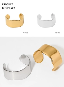 Close-up of polished gold and silver irregular C-shape metal bangles with wave edges