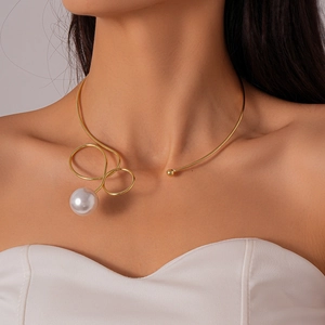 Close-up of golden metallic twisted choker necklace with a large round white pearl on model