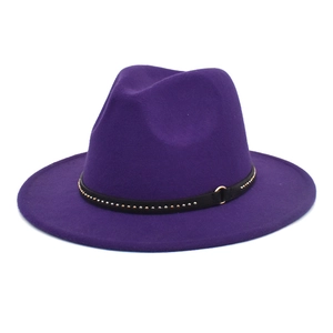 Detail of purple fedora hat featuring black leather band with studs and gold metal buckle