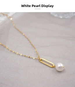 Detail of white pearl pendant with textured gold fastener on elegant slim chain necklace