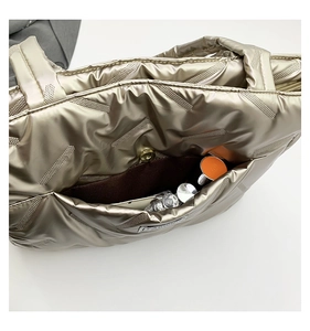 Detail of champagne gold puffy tote bag with geometric dot pattern and magnetic buckle