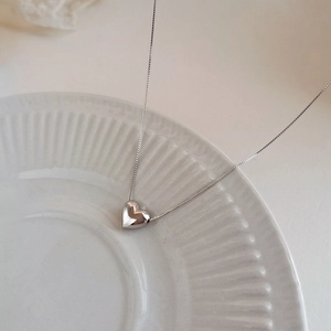Minimalist S925 sterling silver heart pendant necklace on a white ceramic tray