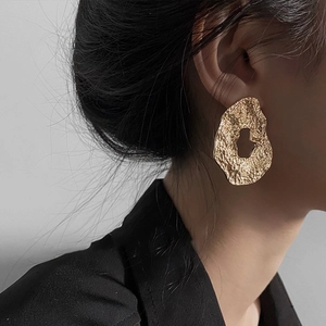 Golden hollow oval hammered earrings with irregular metallic texture for a modern look