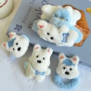 Close-up of plush bear hair ties with 'HAPPY' embroidery in blue and white colors