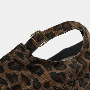 Détail de la casquette léopard avec boucle en métal bronze vintage et tissu en coton