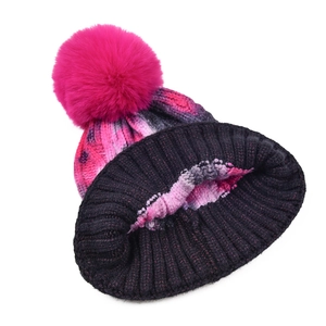 Tie-dye knit beanie with large faux fur pompom and thick ribbed texture for winter warmth