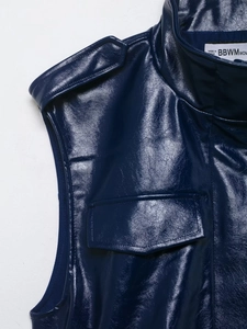 Gros plan du gilet en similicuir bleu marine avec brides à boucle et détails de poche