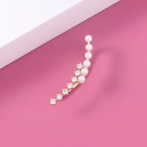 Detail of gold star ear cuff featuring inlaid white pearls and clear cubic zirconia