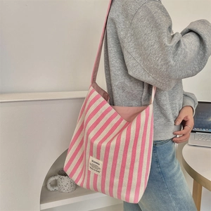 Dettaglio della borsa tote in tela a righe rosa e bianche con etichetta tessuta
