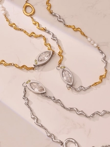 Detailed macro of gold and silver layered chains with marquise stones and pearls