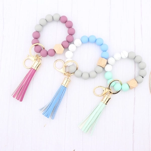 Macro detail of silicone beaded wristlet keychain with wooden bead and leather tassel