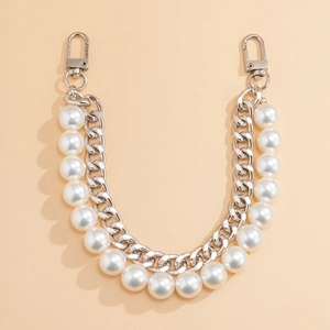 Detail of silver chain strap with white pearls and metal lobster clasps for handbags