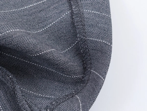Détail macro du tissu à rayures gris foncé montrant le tissage sergé et le surjet