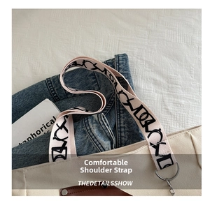 Detail of canvas backpack featuring a wide pink printed strap with abstract patterns