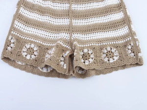 Detail showing khaki and white knit shorts with intricate crochet floral hollow-out trim