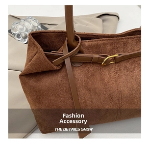 Detail of vintage brown suede tote bag featuring a metal buckle and soft matte texture
