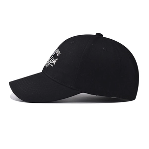 Détail de la casquette de baseball en coton noir avec broderie blanche et coutures sur la visière