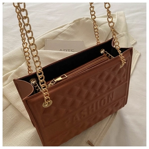 Top view of brown embossed tote bag with gold chains and interior pocket detail