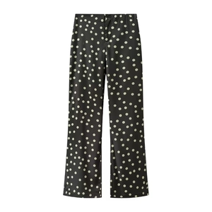 Detail einer Satin-Schlaghose mit hoher Taille und klassischem schwarz-weißem Polka-Dot-Muster