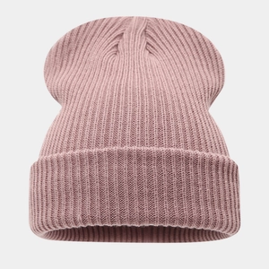 Gros plan du bonnet en maille rose montrant la texture côtelée et le revers large