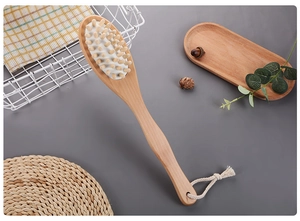 Detailed view of natural wooden bath brush with massage nodes and soft cotton hanging rope