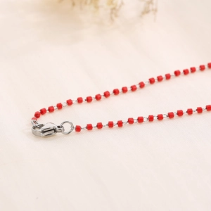 Detail of red enamel beads on silver stainless steel chain with a lobster clasp closure