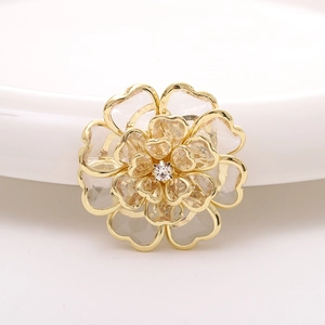 Macro detail of champagne acrylic flower accessory with golden finish and clear rhinestone
