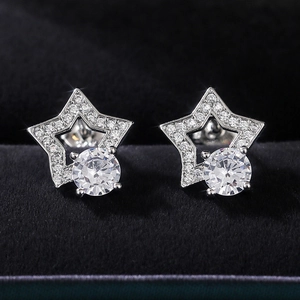 Macro shot of silver star-shaped zircon stud earrings on a premium black velvet box