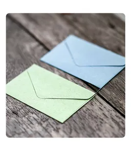 Macro detail of mini vintage textured specialty paper envelopes on rustic wood surface