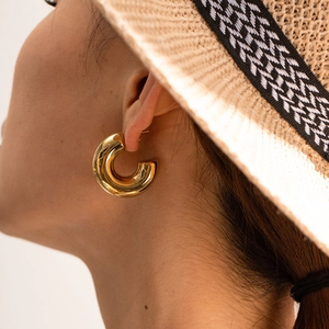 Detailed side view of thick 18K gold-plated chunky C-shape earrings worn by a model