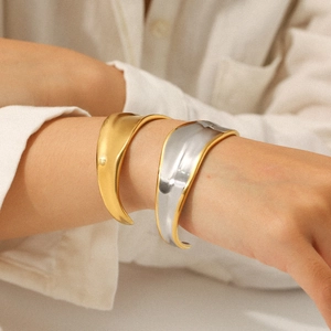 Polished 18K gold and two-tone stainless steel chunky open cuff bracelet on model