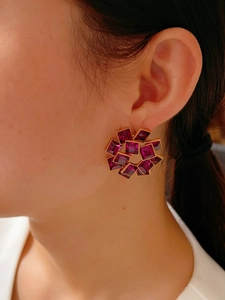 Detail of vintage gold-plated earrings with purple square crystal and geometric hollow ring