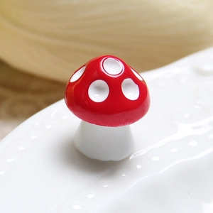 Detailed close-up of a 14mm red resin mushroom miniature with white dots for DIY crafts
