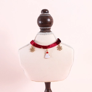 Detail of red velvet pet collar with festive golden snowflake and Christmas tree pendants