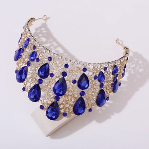 Close-up of golden baroque tiara featuring intricate blue teardrop crystals and rhinestones
