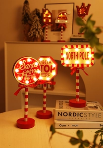 Close-up of North Pole LED Christmas stop sign with wooden base and festive red glow