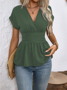 Close-up of deep green V-neck pleated top paired with slim fit blue denim jeans