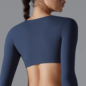Dettaglio del top da yoga corto a maniche lunghe blu navy con tessuto elastico testurizzato